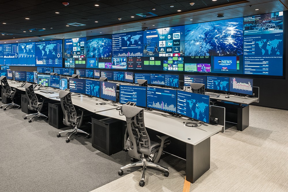 a large room with lots of monitors including news stations and graphs