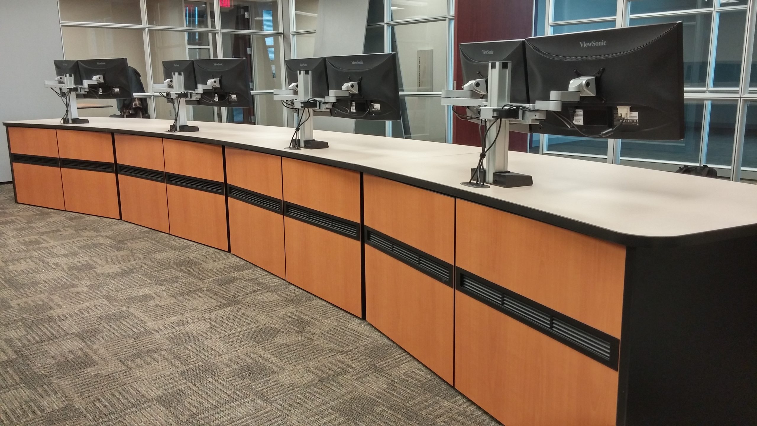 backside of console desks with mounted monitors in operations center