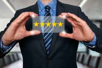 A man in a suit holding up a 5-star plaque