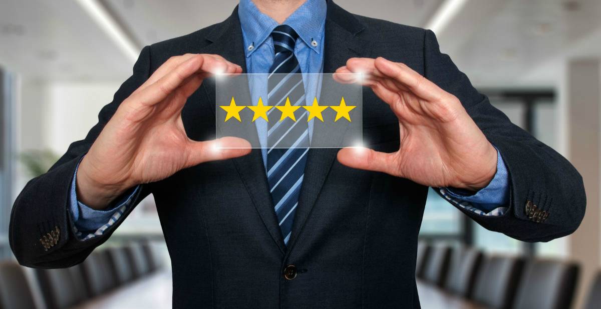A man in a suit holding up a 5-star plaque
