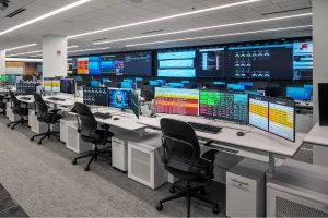 rows of consoles in a GSOC facing large video wall