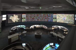overview of a utilities control room featuring operator consoles and a large video wall displaying critical data