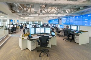 view of large operations center with video wall and console desks. 